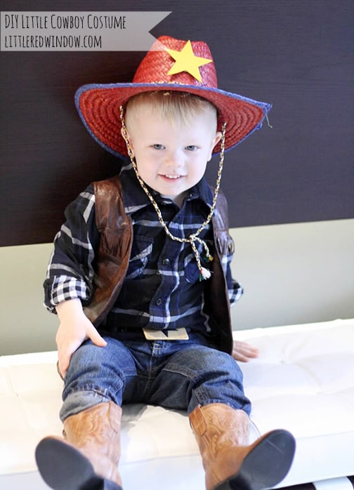 toddler sitting on a bench wearing a cowboy costume