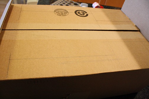 Top flaps of a cardboard box with pencil lines drawn on it