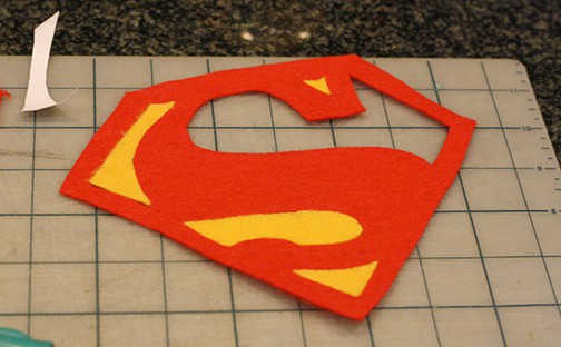 Red felt superman logo with the background areas filled with yellow felt