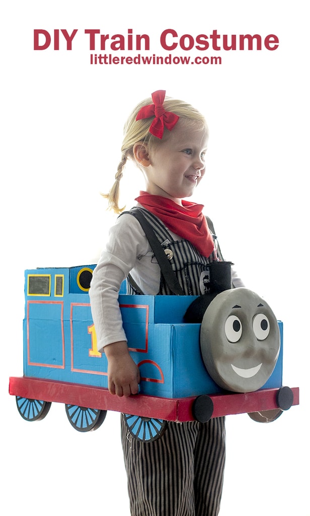 Little girl with braids wearing engineer costume and Thomas the Train box costume
