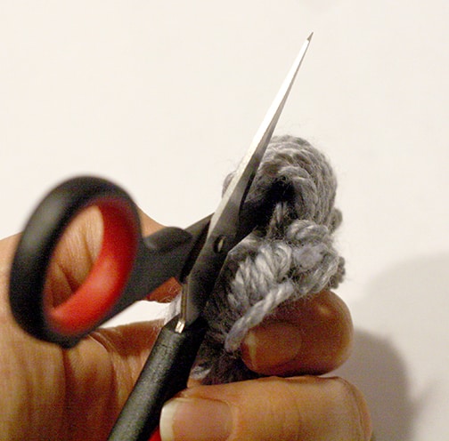 a scissors cutting through the yarn bundle 