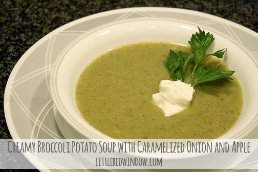 White bowl of green broccoli soup with sprig of parsley and dollop of sour cream