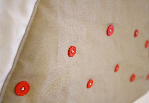 closeup of red buttons on tan fabric