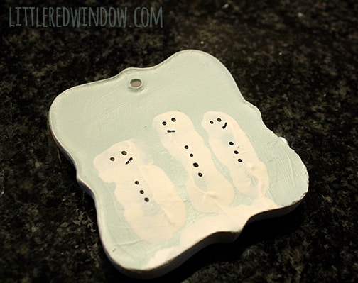 handpainted black buttons and faces added to the white snowman fingerprint shapes