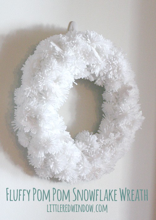 White pom pom wreath hanging on a wall 
