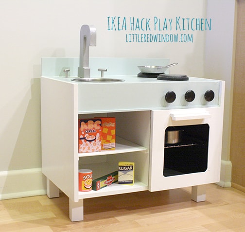 Cute white and blue kid's play kitchen with shelves, sink, stovetop and oven