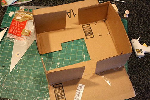 Strips of cardboard attached to sewing machine shape to make the sides