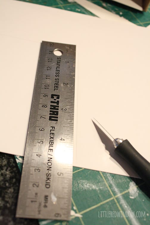 piece of white cardstock, metal ruler and craft knife