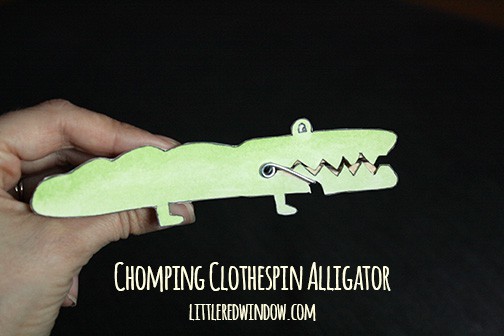 Aligator clothespin animal with mouth open and fish inside