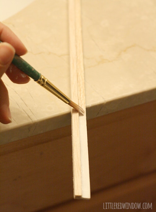 Paintbrush painting wood strips white