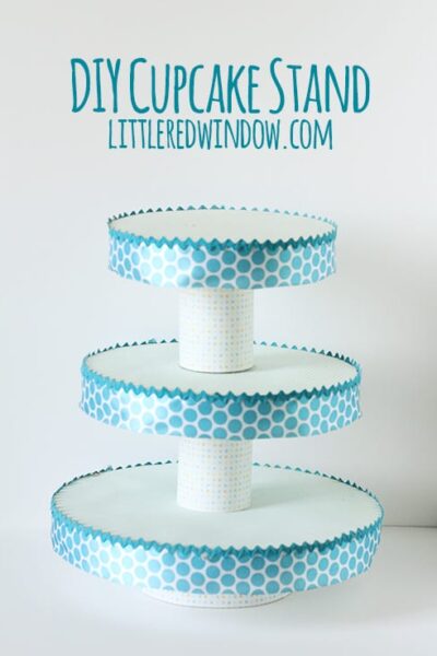 Cupcake stand with three tiers and teal polka dot ribbon around the edges
