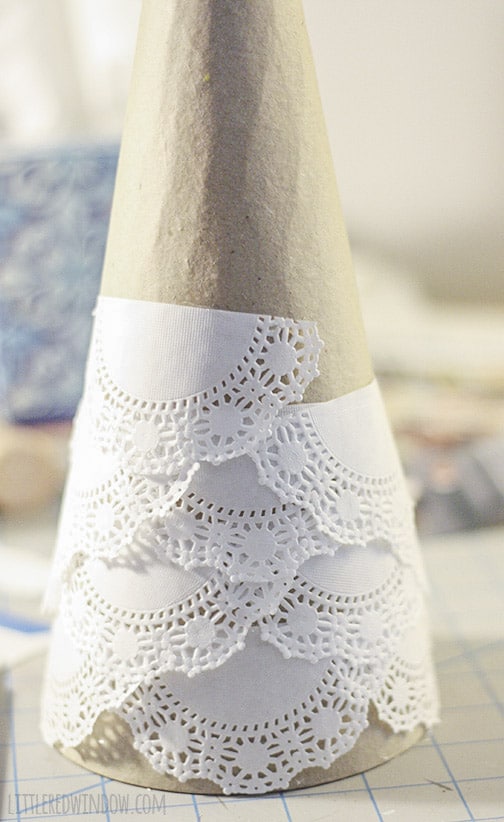 Paper mache cone being covered with doilies