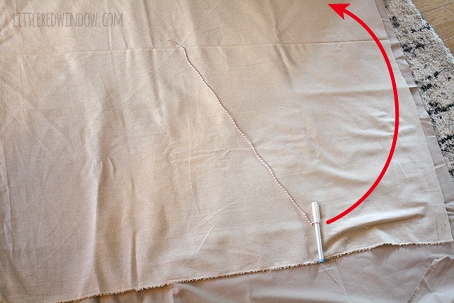 fabric laid out with fabric pen tied to a string and a red line showing how to use that to draw a circle