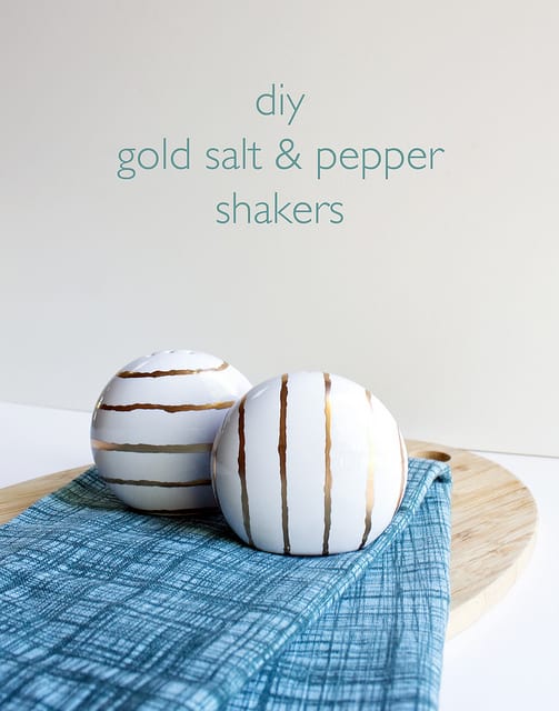 White ceramic spherical salt and peper shakers with gold stripes