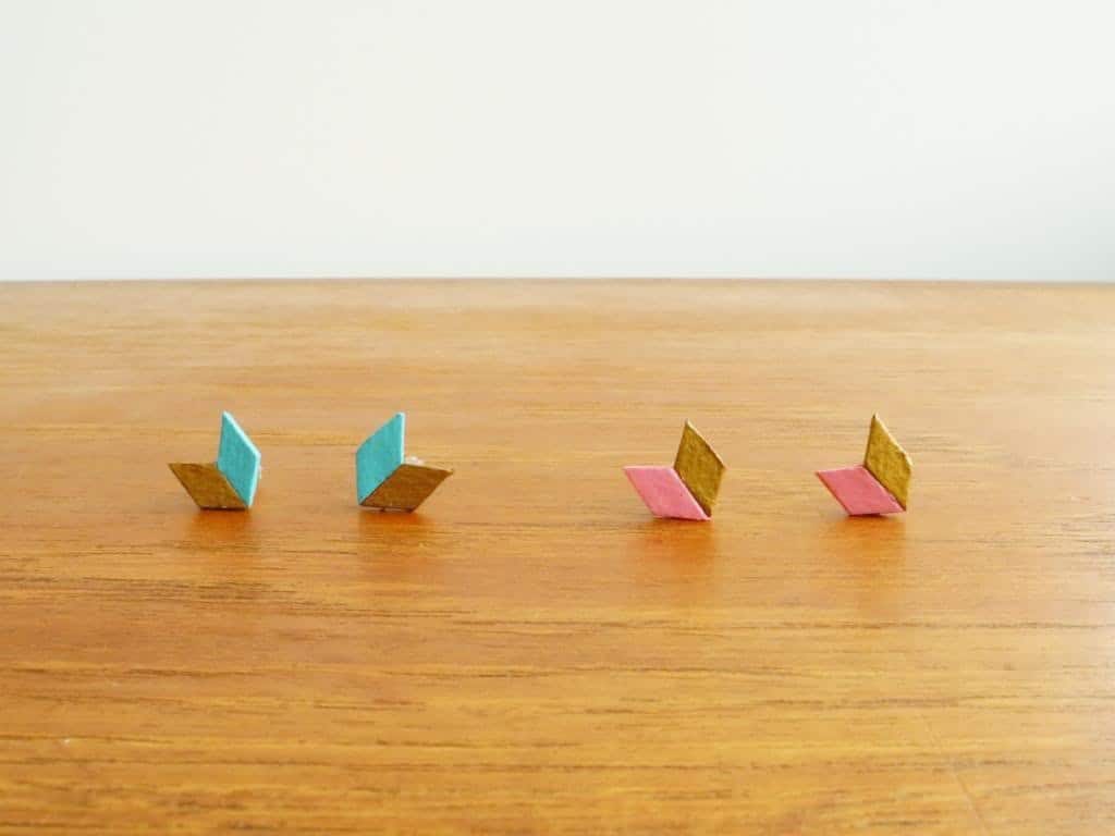 Two pairs of small chevron shaped stud earrings on a table