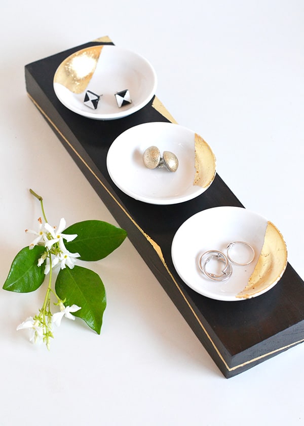Black rectangle with three small circular dishes to hold jewelry