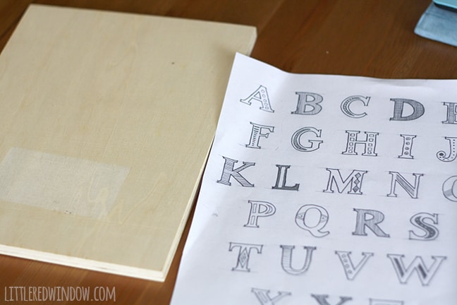 piece of paper with alphabet design next to wood canvas