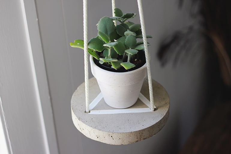 round concrete shelf held up by white rope