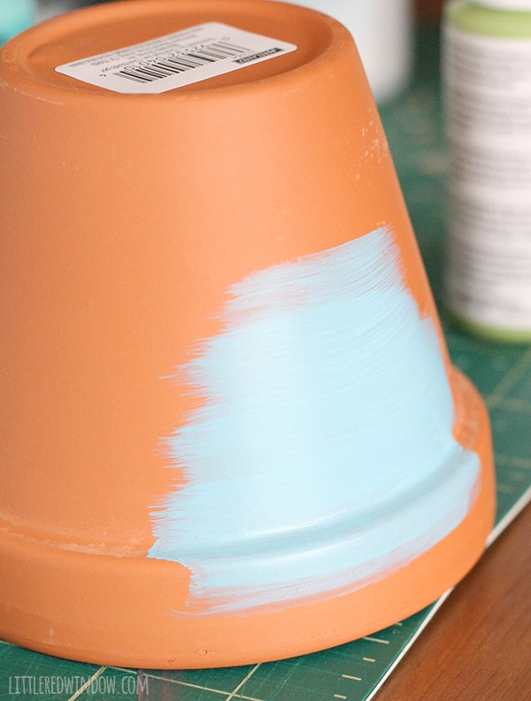 flower pot upside down being painted blue 