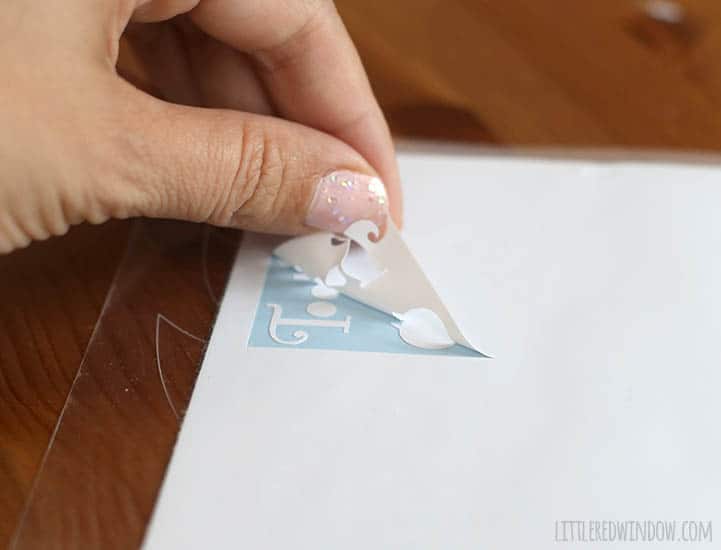 hand peeling off the background from a white vinyl label