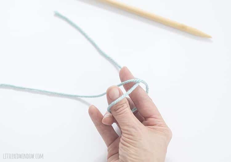 To make a slip knot, reach through the loop you just created and grab the working end of the yarn