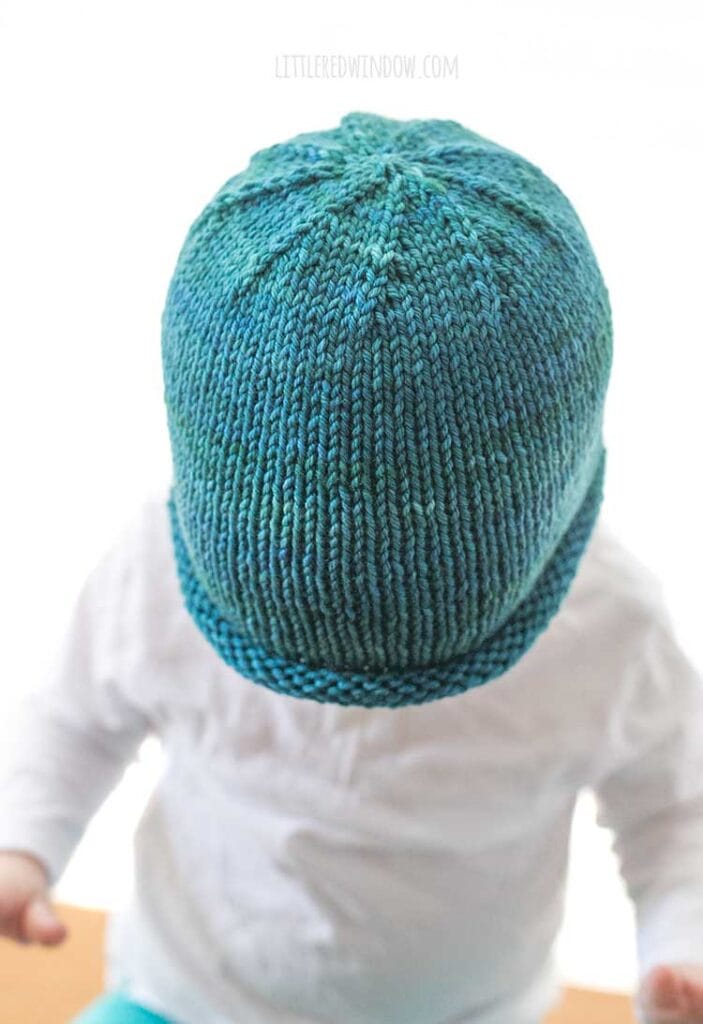 view from above of teal hand dyed yarn knit rolled brim hat pattern to show the decreases