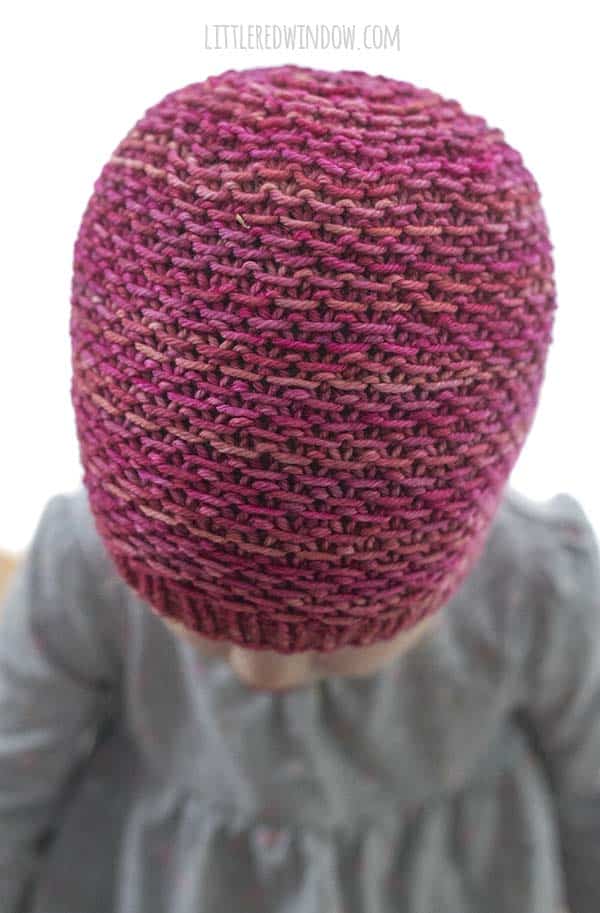Closeup top view of magenta colored knit hat and the slipped purl or honeycomb knitting stitch