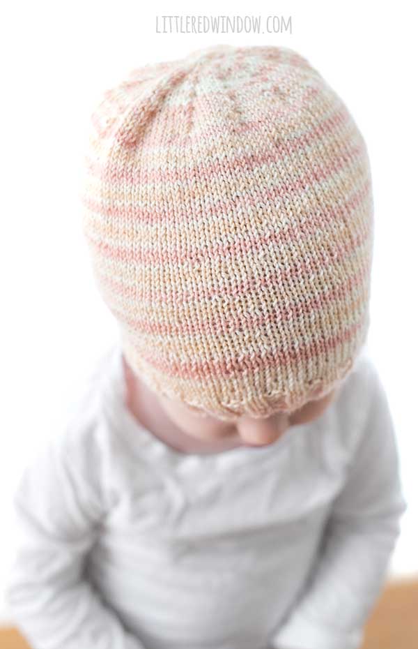 view from above of baby wearing light pink sock yarn hat