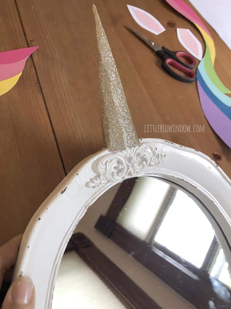 Attach the golden horn to your DIY unicorn mirror with hot glue