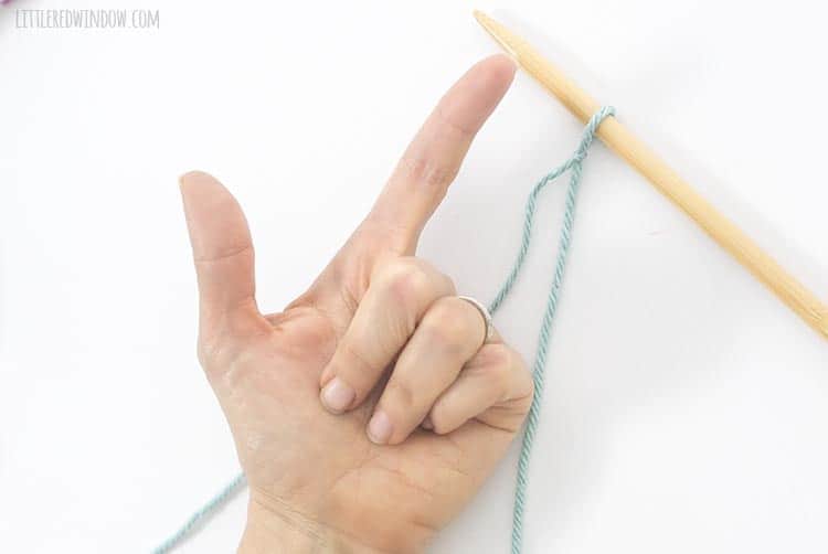 Hold your left hand with thumb and pointer out to start a backward loop cast on