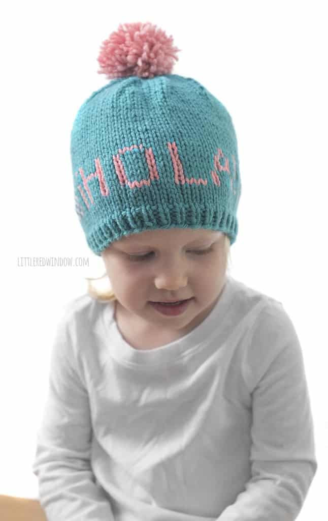 Cute baby wearing a Greetings baby hat that says "hola!"