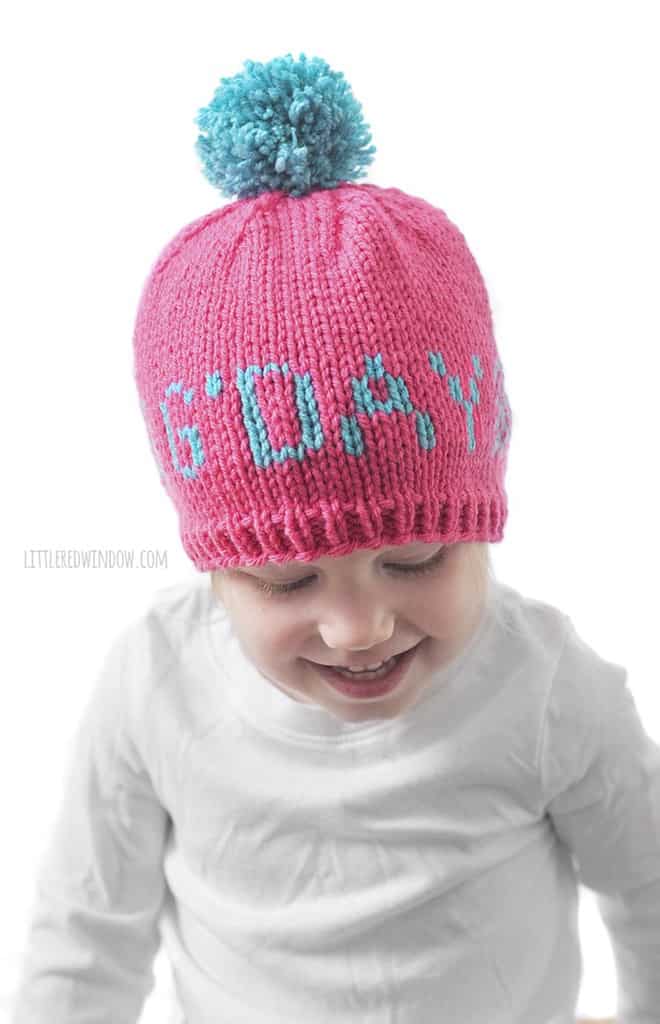 Cute baby wearing a Greetings baby hat that says 