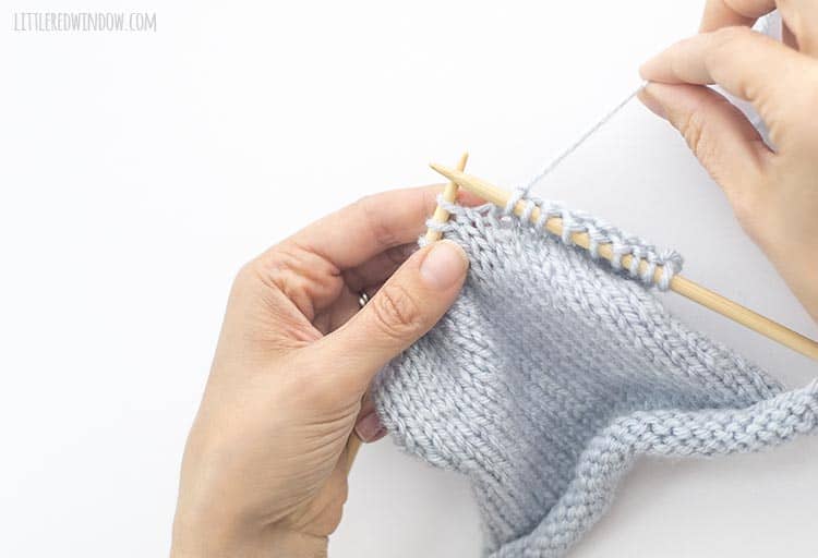 To do a yarn over between knit stitches, hold the yarn behind the work.