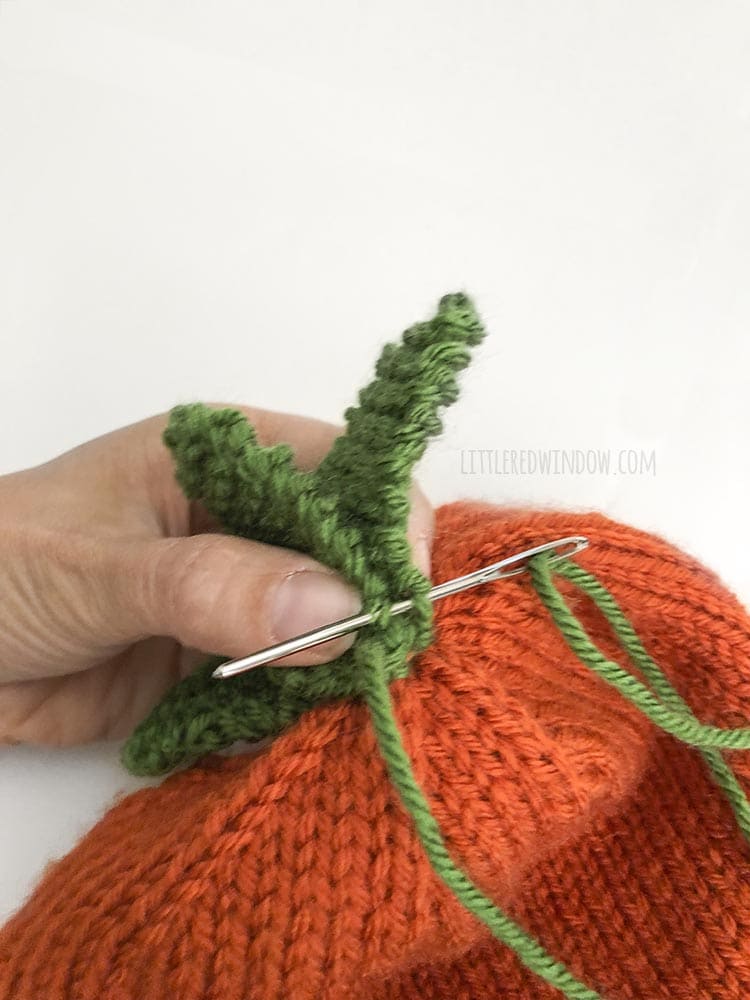 Sew the knit carrot leaves to the top of the baby carrot hat
