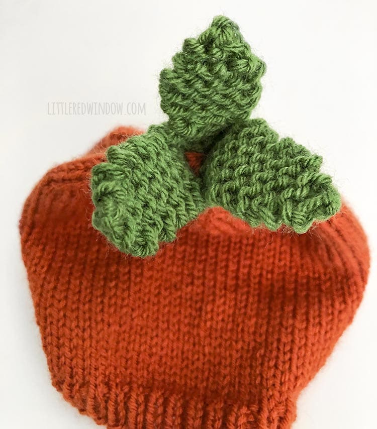 Sew the knit carrot leaves to the top of the baby carrot hat