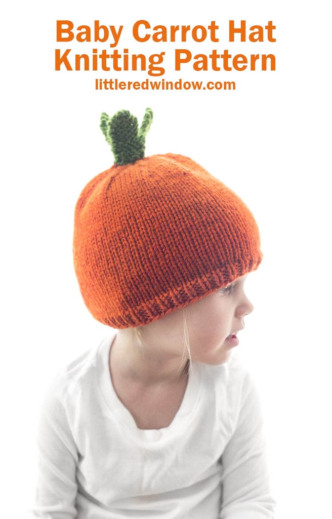 little girl in white shirt wearing an orange carrot hat with green leaves on top looking off to the right