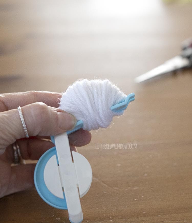 Use a pom pom maker to make 2 pom poms from white worsted weight yarn!