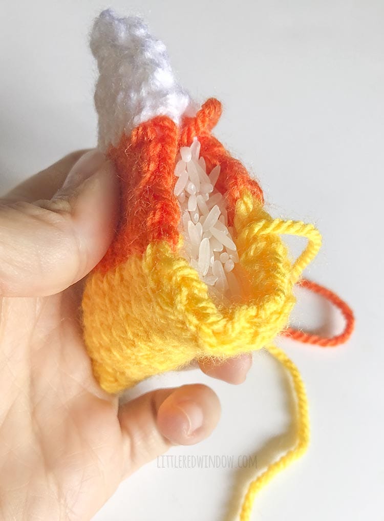 knit candy corn handwarmer being filled with white rice