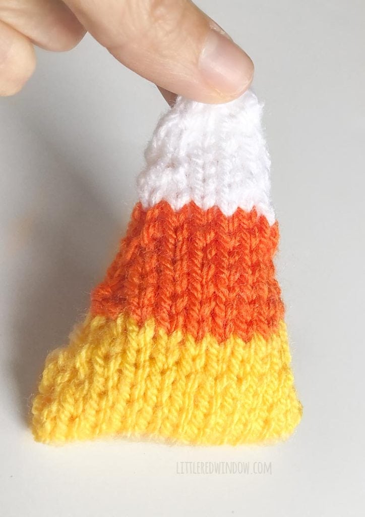 hand holding finished knit candy corn shape