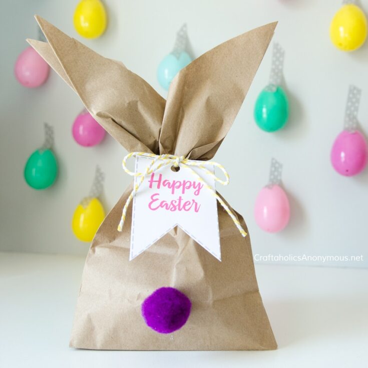 brown paper bag folded to look like bunny ears with a pom pom tail on the front