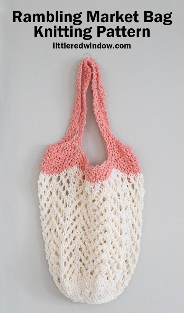 cream and coral lace knit market bag hanging on a hook in front of a gray wall