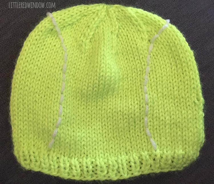 completed tennis ball hat with two lines of white embroidered stitches curving along the sides like a real tennis ball