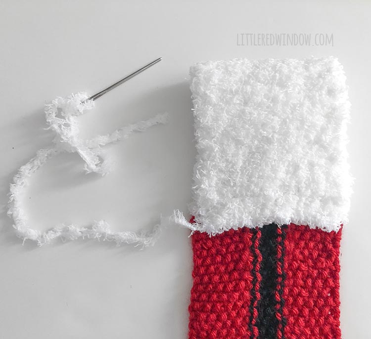 christmas scarf with white fluffy end folded to form the loop