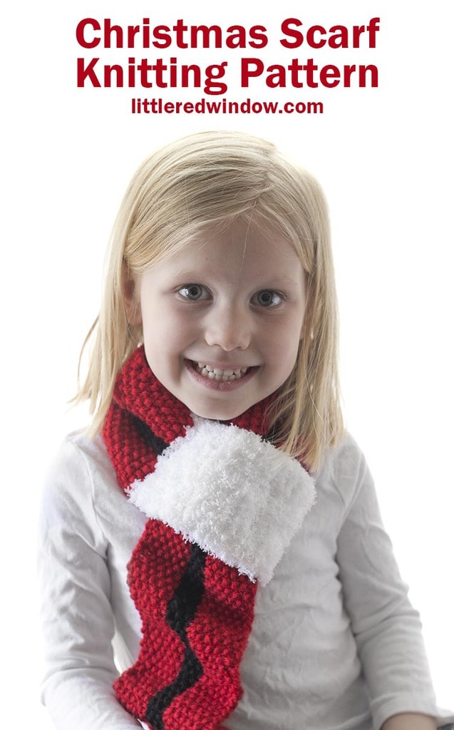 smiling girl wearing red christmas scarf with black stripe and white fluffy end