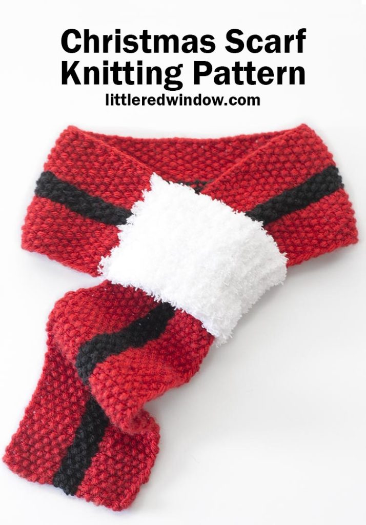 red knit christmas scarf with black stripe down the center and white fluffy loop at one end on a white background