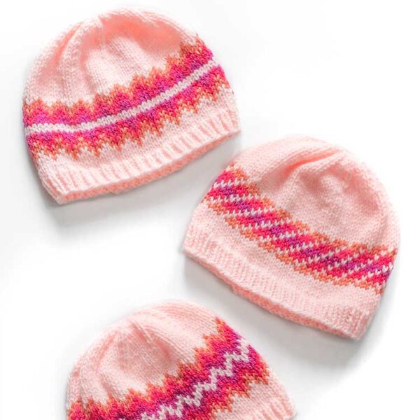 three pink orange magenta and purple knit hats with different sunset fade patterns