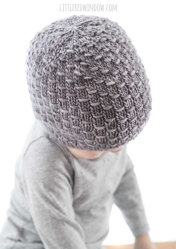 little girl leaning down and wearing a gray knit elm grain hat
