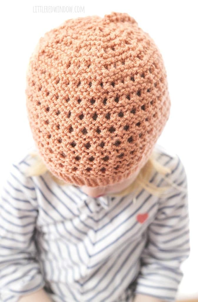 closeup of stitch detail on coral colored knit lace grid hat