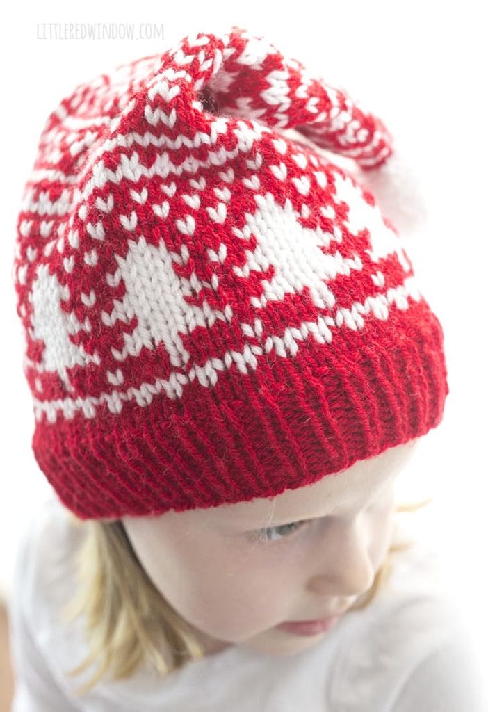 closeup of tree motifs on red and white knit fair isle stocking cap