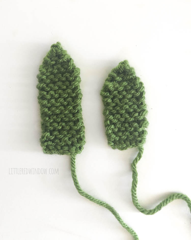 one short and one tall green knit pineapple leaf on a white background
